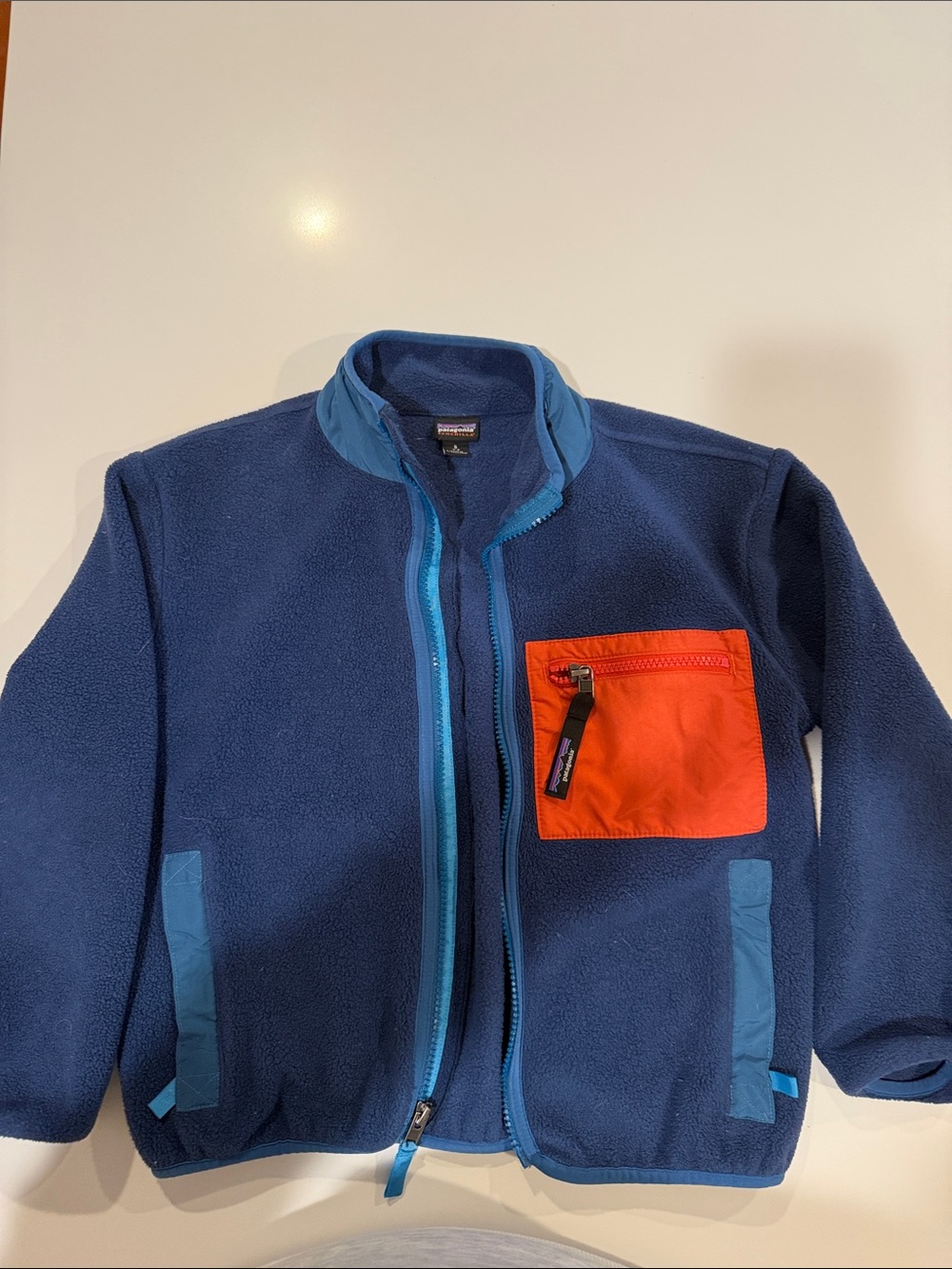 Patagonia Kids Navy Fleece Jacket with Bright Orange Chest Pocket